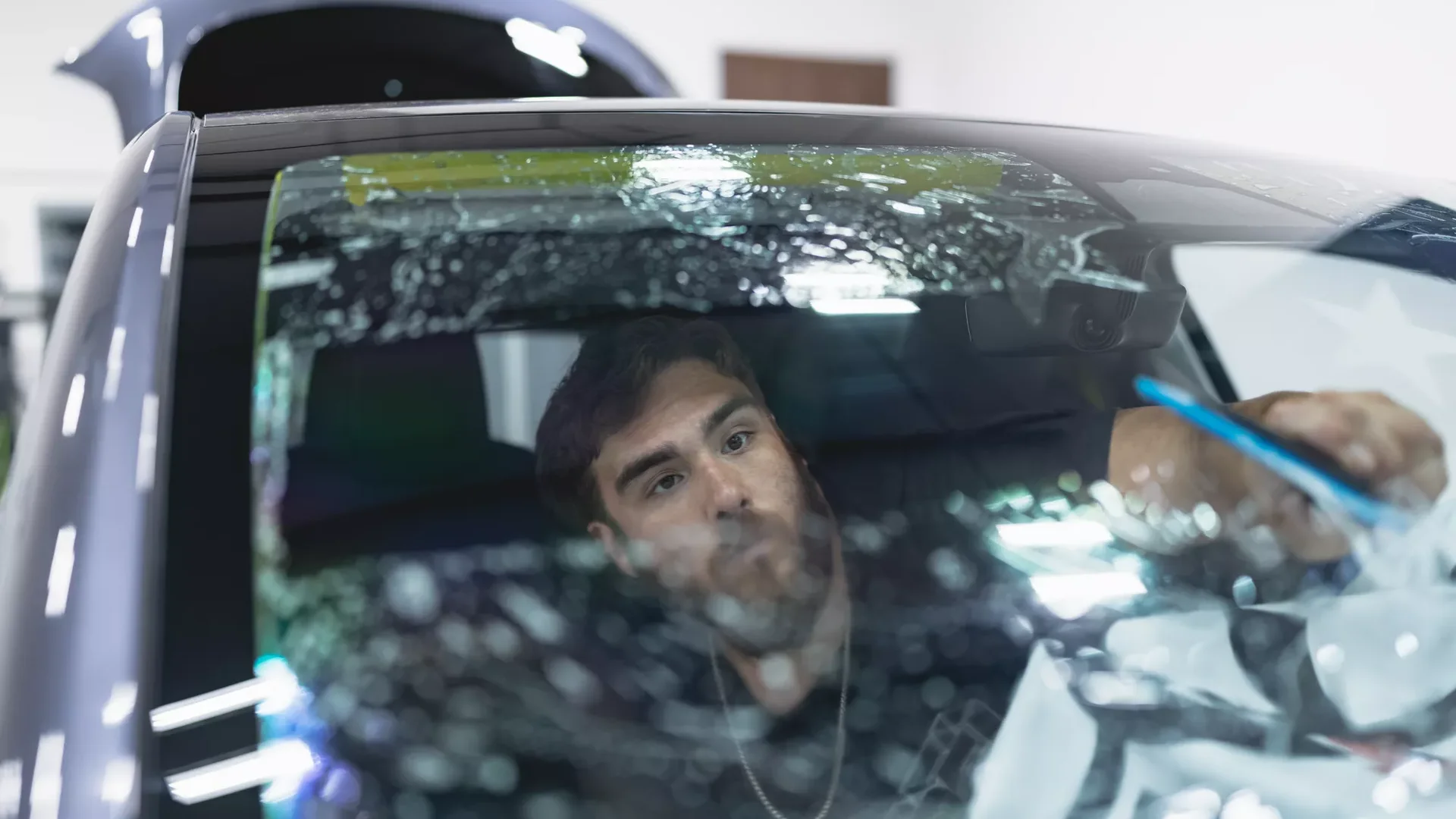 An installer applying XPEL window film to a vehicle windshield